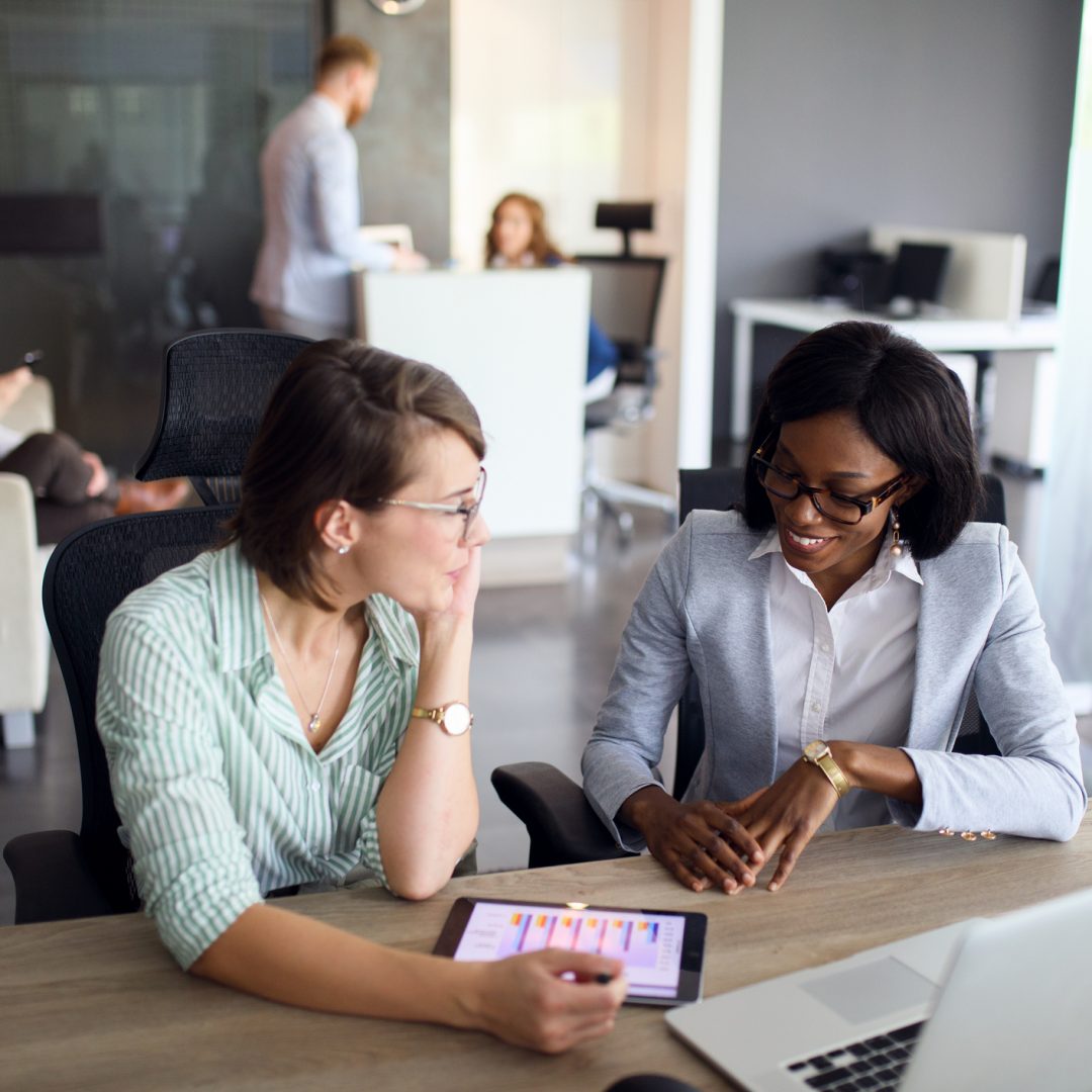 Businesswomen analyzing bar graph using digital tablet